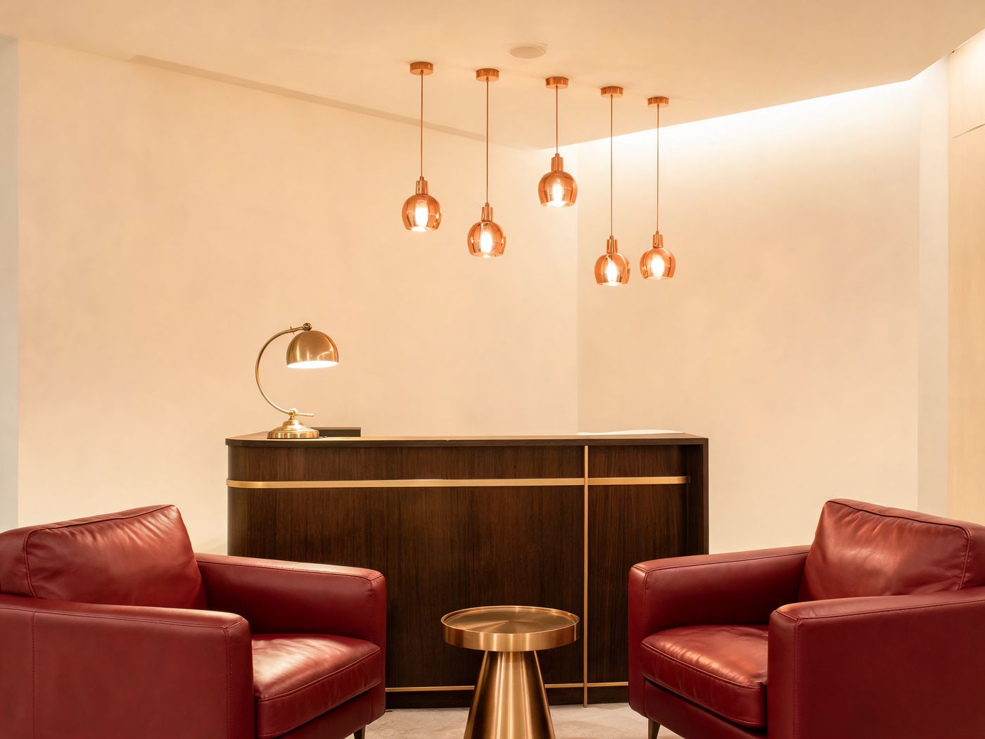 Warm office reception with leather chairs and copper lighting